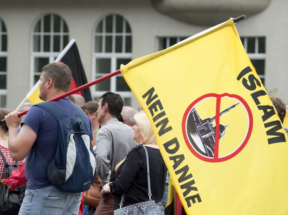 A supporter of the right-wing organization, Patriotic Europeans say No, PEsN, holding a flag reading ,Islam, no thanks, during a rally in Erfurt, central Germany, June 4, 2016.