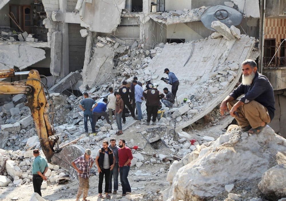 Syrian civil defense volunteers search for victims amid the rubble of destroyed buildings on Oct. 24, following overnight air strikes in the opposition-held town of Kafar Takharim, in the Idlib province of northwest Syria.