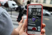 This picture taken on July 26, 2016 near the Louvre museum's pyramide in Paris shows the 'Pokemon Go' app on the screen of a smartphone. (AFP Photo)