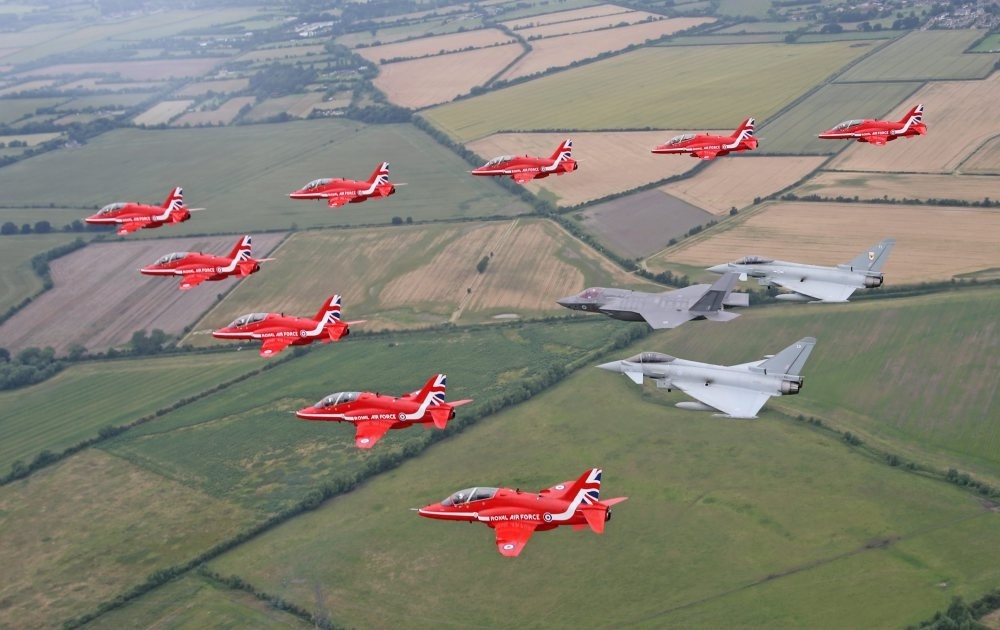 Jet aircraft from the British Royal Air Force Aerobatic Team, the Red Arrows, in formation with two Typhoons and the F-35B Lightning II over Gloucestershire.