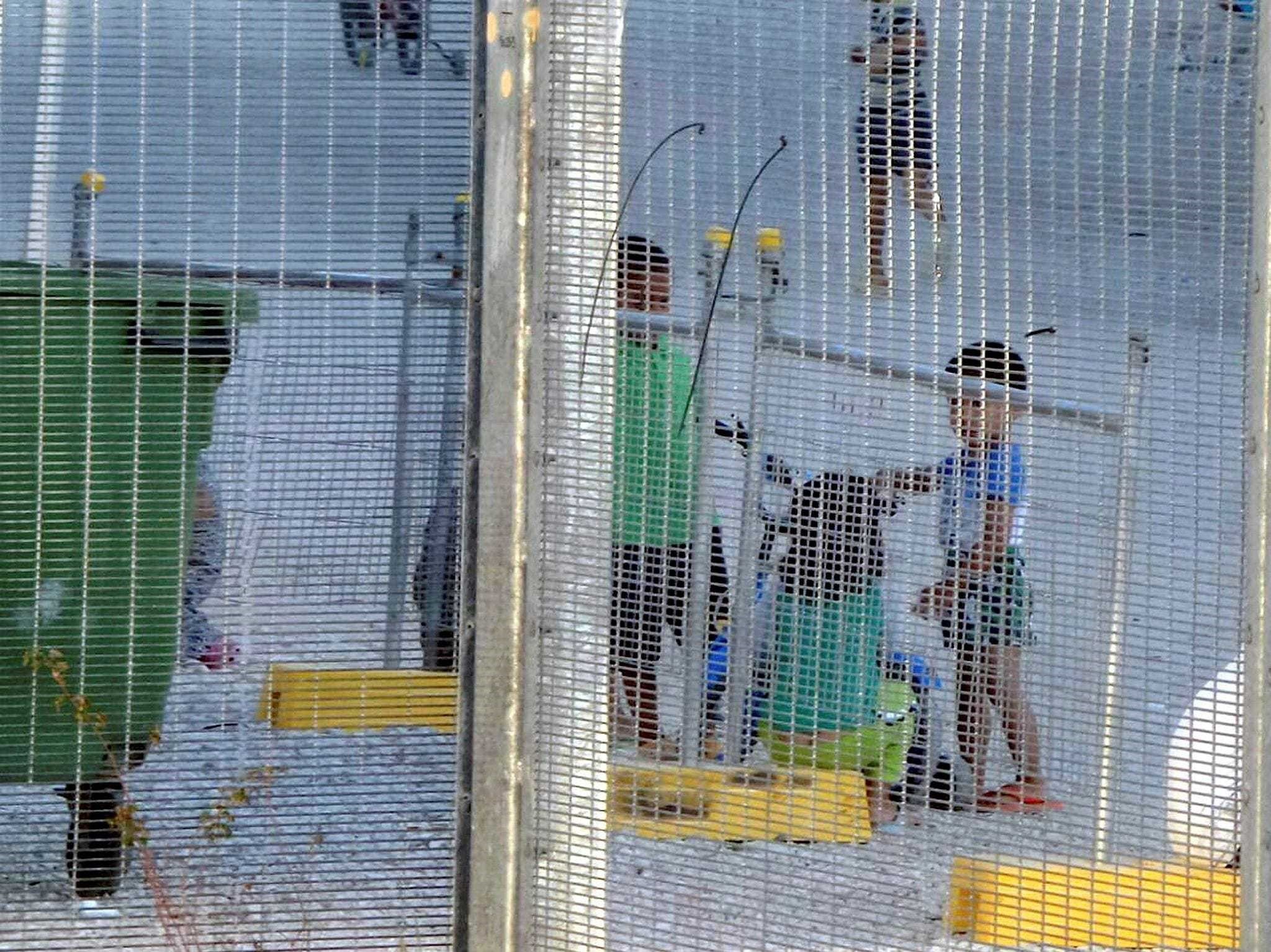 Children play near a fence at the country's Australian-run detention center on the Pacific island nation of Nauru.