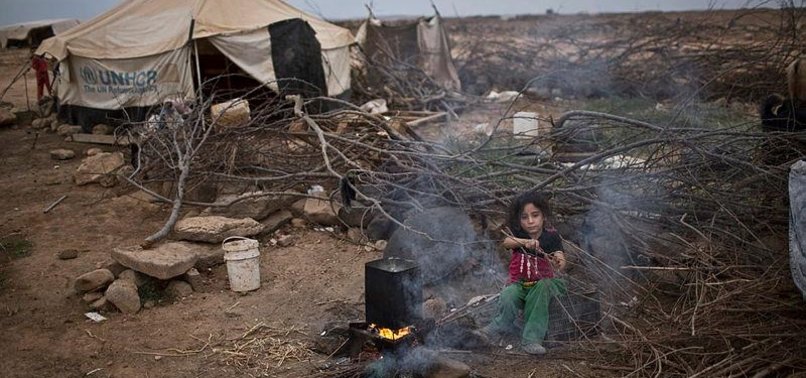 SYRIAN REFUGEES NEAR BORDER BURN CLOTHES TO STAY WARM