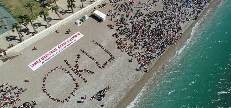 THOUSANDS OF STUDENTS READ BOOKS ON SOUTHERN TURKISH BEACH UNDER LOCAL PROJECT