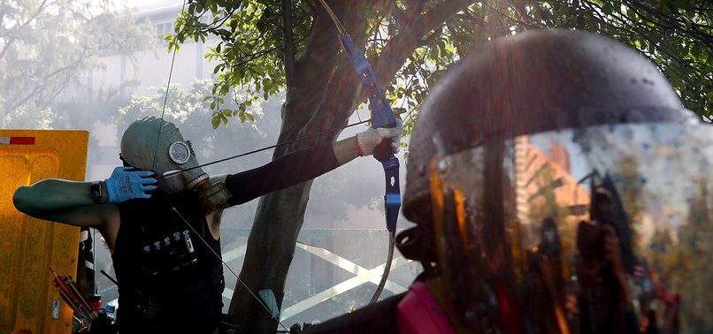 OFFICER HIT BY ARROW IN HONG KONG PROTESTS AS POLICE FIRE WATER CANNONS