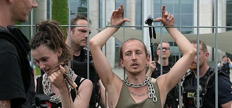 CLIMATE PROTESTERS CHAIN THEMSELVES TO MERKELS CHANCELLERY