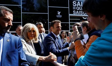 Macron casts vote, meets supporters outside polling station