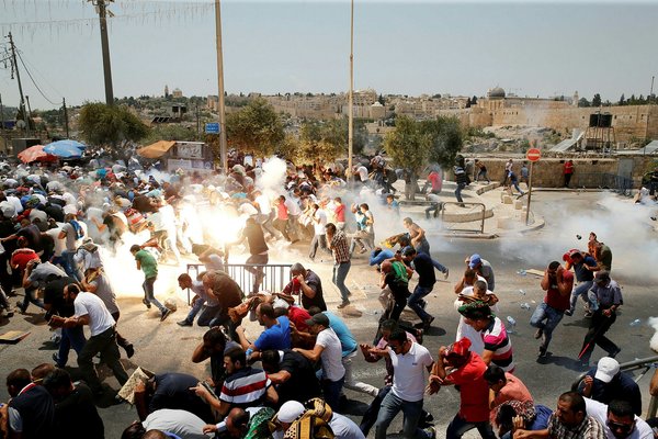 Palestinians react following tear gas that was shot by Israeli forces after Friday prayer on a street outside Jerusalem's Old city July 21, 2017. (Reuters) 