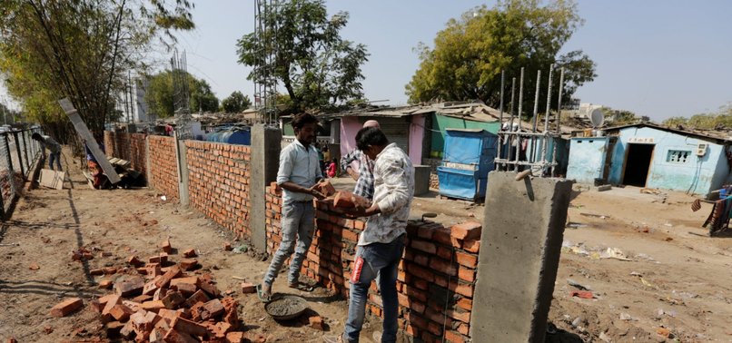 INDIA HASTILY BUILDS WALL ALONG SLUM AHEAD OF TRUMP VISIT