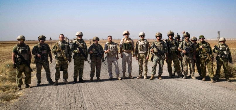 RUSSIAN, US TROOPS EXCHANGE FRIENDLY GREETINGS AND POSE FOR PICTURES TOGETHER IN NORTHEAST SYRIA