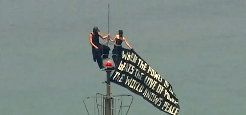 MASKED COUPLE SCALES EMPIRE STATE BUILDING IN NEW YORK, UNFURLS PEACE BANNER
